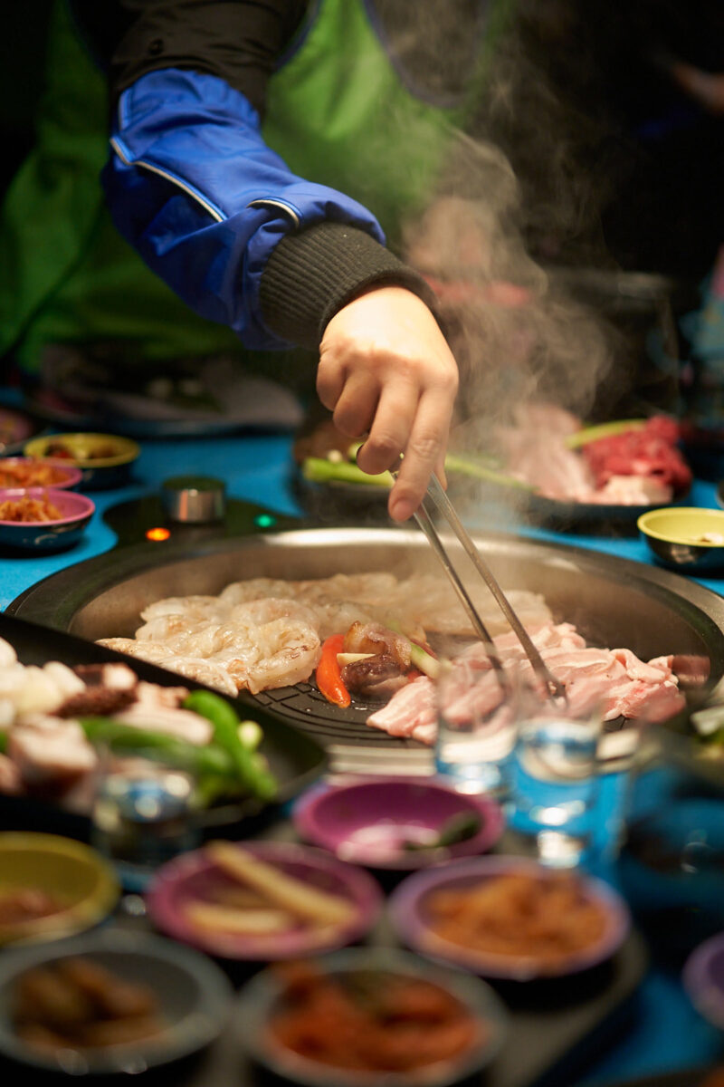 Food on the in-table grill at Gunbae Korean BBQ.